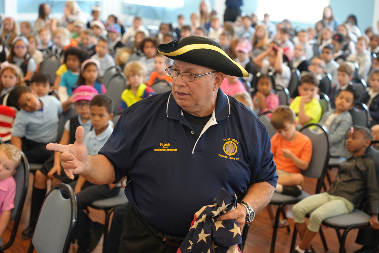 Frank Colón, commander of American Legion Post 303 in Rockville Centre teaches students at St. Agnes Cathedral School about flag etiquette.