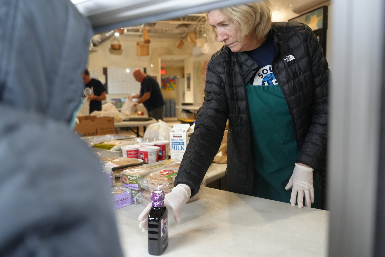 Volunteer Eilleen Heneghan handing out groceries at the Long Beach Soup Kitchen’s weekly pantry.