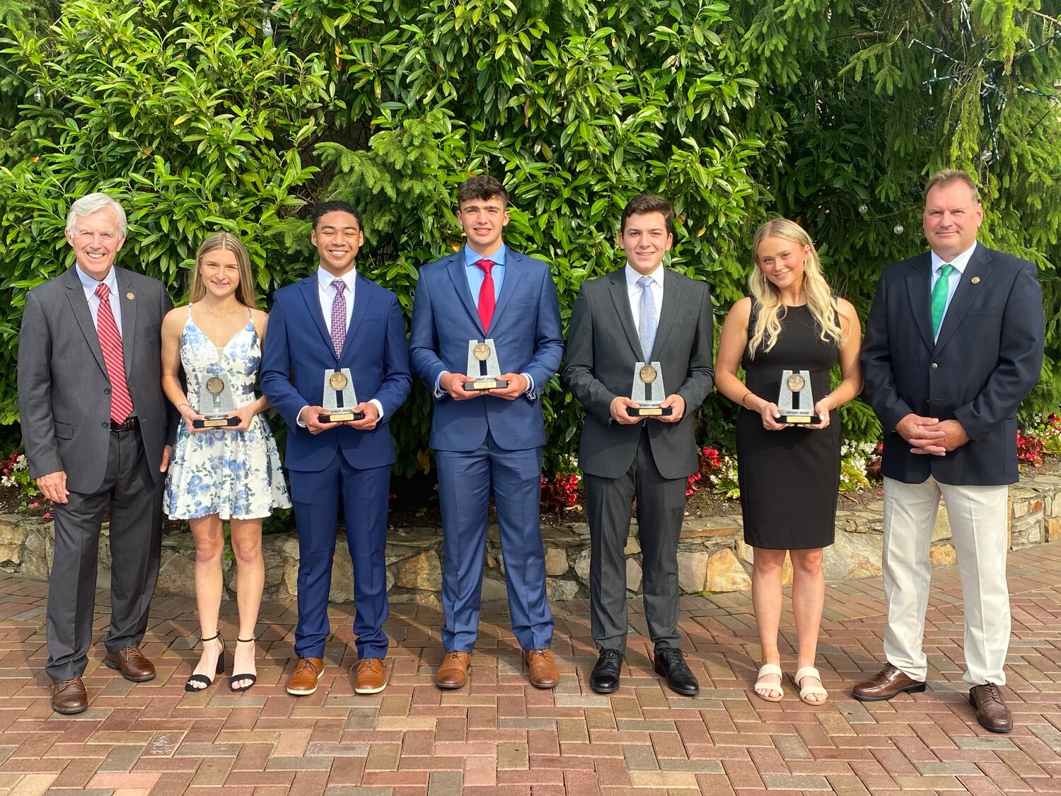 Seaford 9/11 Memorial Committee Chairman Tom Condon, far left, 2023 Patriot Award winners Nicole Nietsch, Ryan Baldwin, William Kind, William Cascio and Jamie Young, and committee President Ken Haskell, the brother of Timothy and Thomas Haskell.