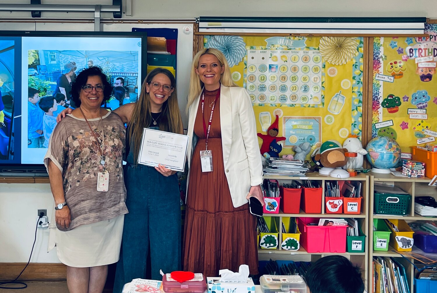 Jaime Teich, Love Your Neighbor Project’s chief neighbor, center, presented a scholarship to the Sea Cliff School’s Garden Club, which was accepted by the club’s advisor Mojdeh Hassani, left, and the Sea Cliff School principal Megan McCormick.
