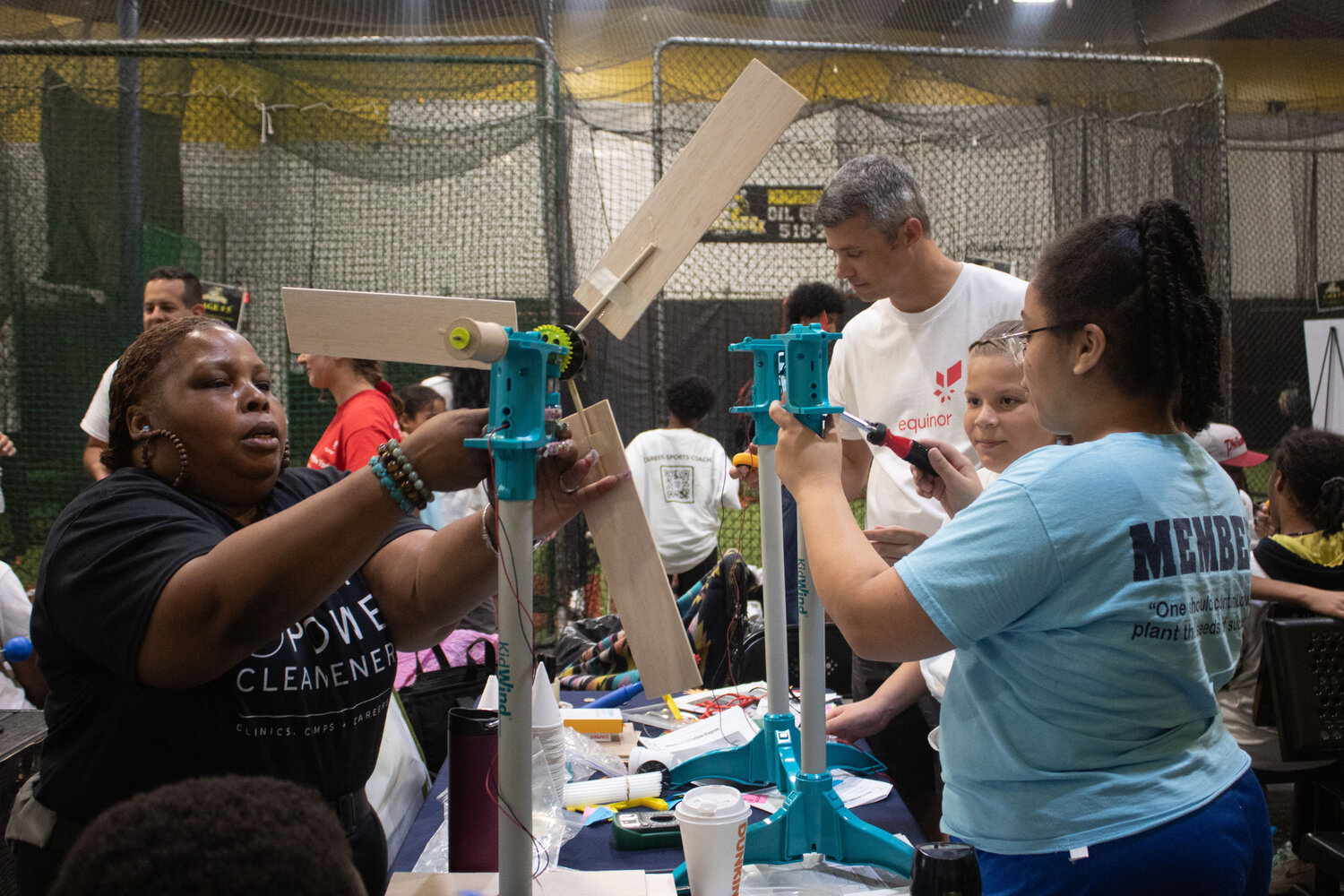 Student-Athletes at the Sports Power Clean Energy clinic in Oceanside work with Equinor staff to learn about how offshore wind turbines work and build their own scale model of a turbine.