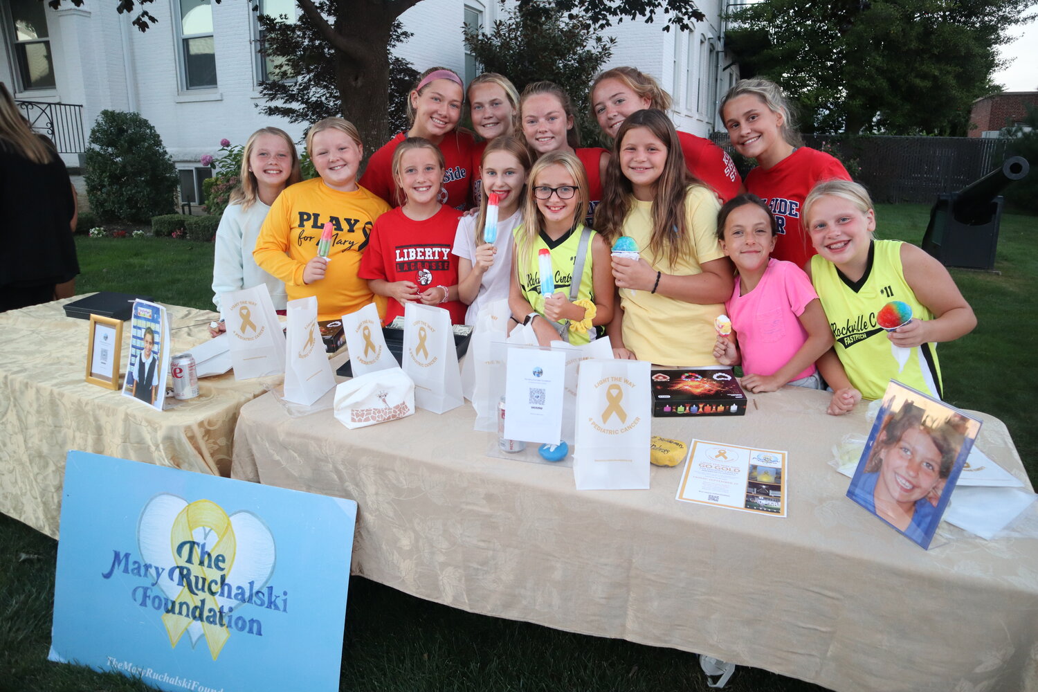 Kids help lend a hand to the Mary Ruchalski Foundation by selling gold bows and luminarias to ‘Light it Up Gold’ for pediatric cancer awareness month.