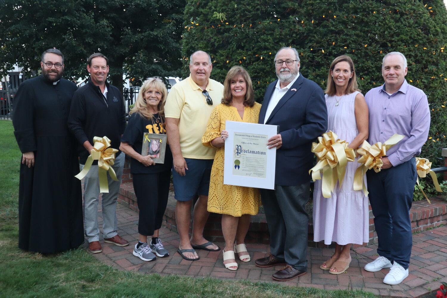 Father Michael Duffy of St. Agnes Cathedral, left, joins Village Trustee Gregory Shaughnessy, Marie Giallombardo, whose daughter Gina died of the same rare form of cancer, Fran and Carol Ruchalski, Rockville Centre Mayor Francis Murray, Village Trustees Katie Conlon and Emilio Grillo in presenting a proclamation in recognition of all the hard work the Mary Ruchalski Foundation has done towards finding a cure.