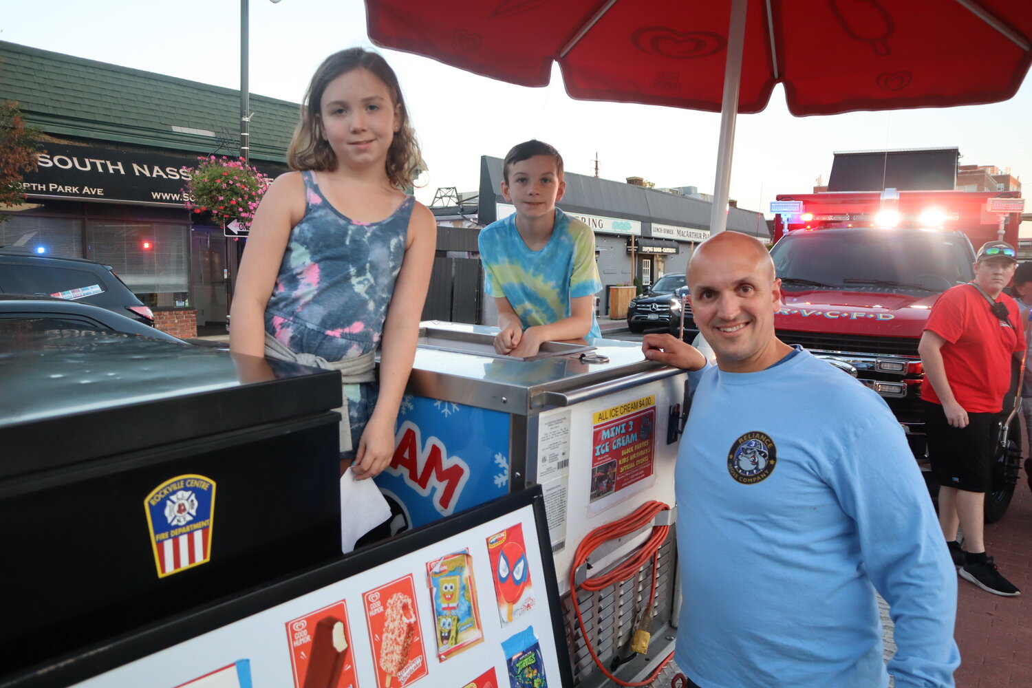 Michael Blackford with Reliance Hose Company No. 3 and his two kids, Lily and Liam, help give out ice cream to the kids during the tree lighting ceremony on Aug. 31.