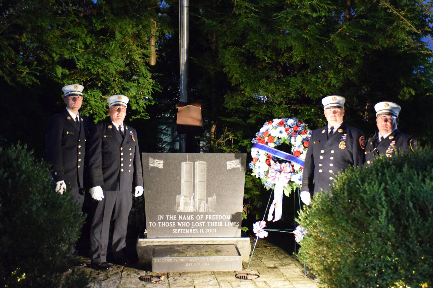 The fire department’s chiefs, at left, around the memorial — an 1,800-pound marble slab, that bears the name of seven east Meadow residents that died in the attacks.