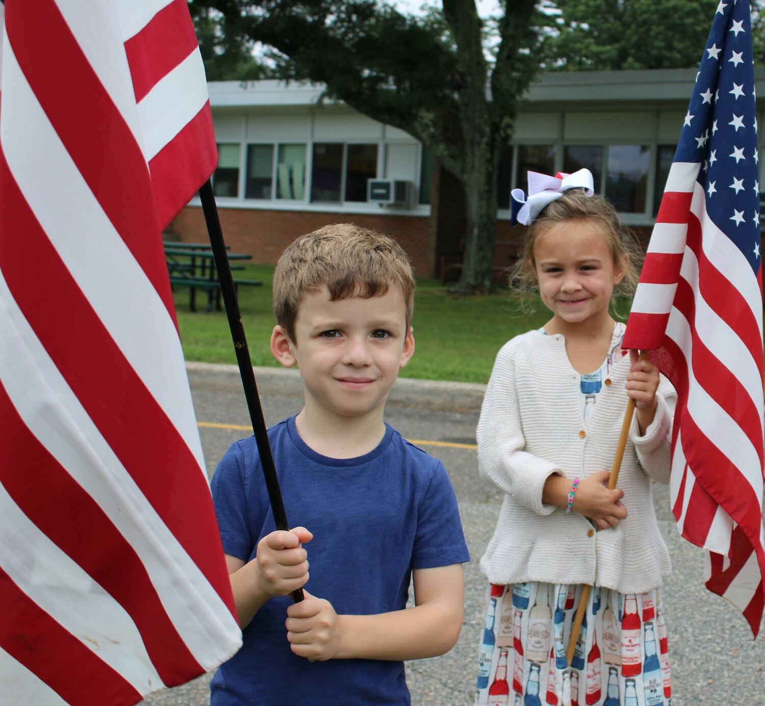 Ann MacArthur Primary School students Bryce Giraldi, left, and Emersyn Maher waved their flags during the ceremony.