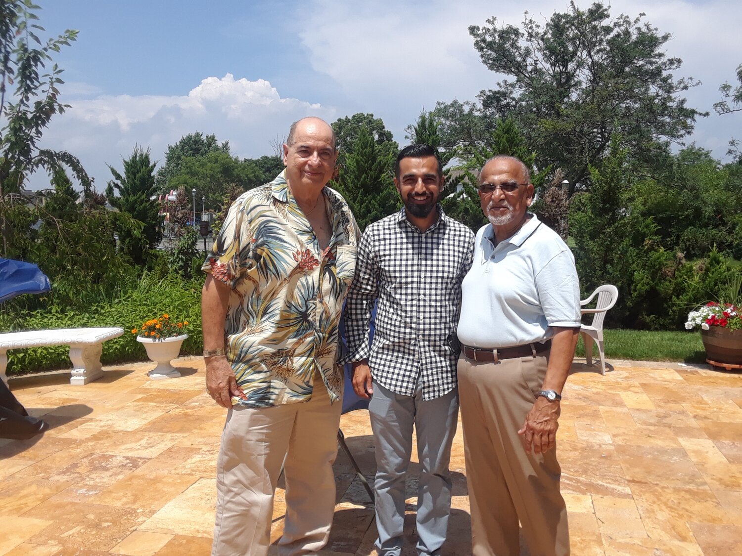Island Park Public Library board President Joe Pontecorvo with Ubaid and Usman Bandukra.