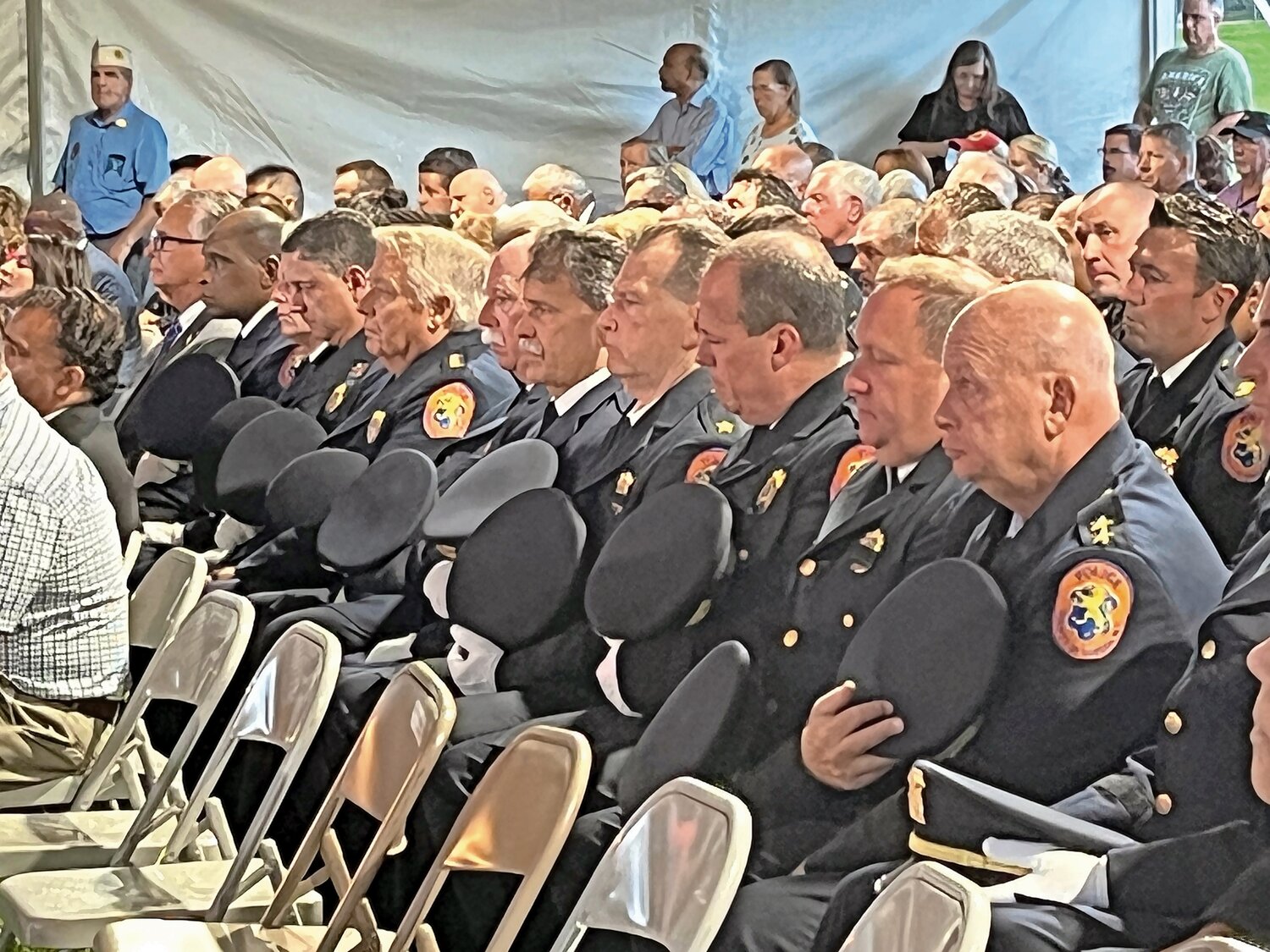 Members of the Nassau County Police Department remove their hats during one of several prayers shared during the Nassau County’s 9/11 Remembrance Ceremony and Musical Tribute at Eisenhower Park on Monday.