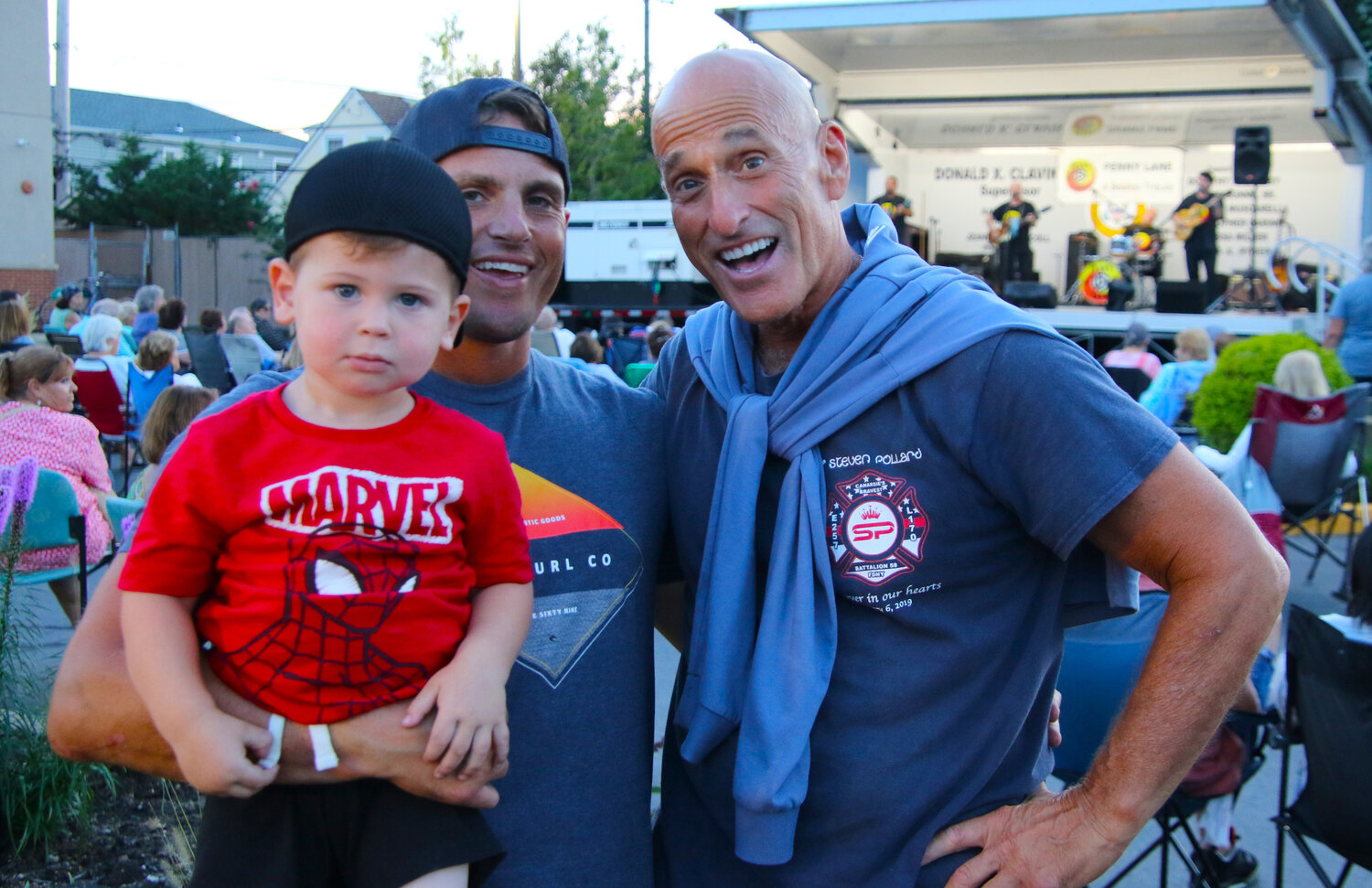 From one generation to another, young Jake Elfant loves the live music and spiderman, as his father Bryan holds his son and with grandfather Bruce all loving the Beatle songs being played live at the Island Park library.