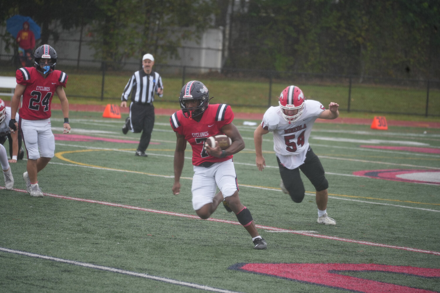 Running back Justin Singh carrying the ball past the Mineola defense.