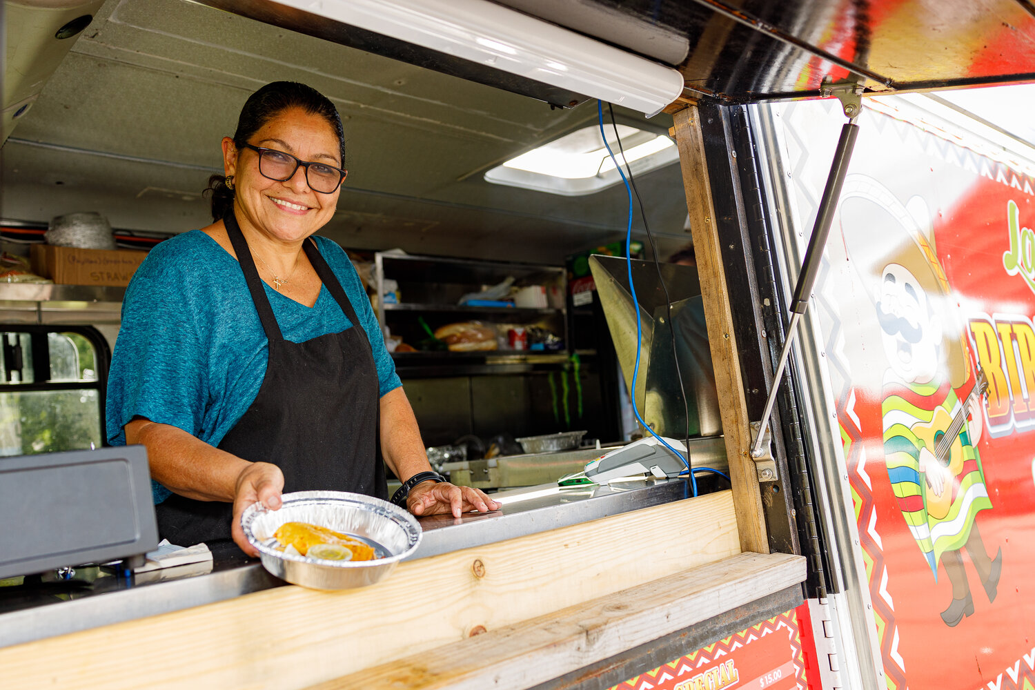 Food vendor Sofia Aguilar of Mamma Mia, a fiesta birria taco truck, serves up savory delights at the Valley Stream Hispanic Heritage Month event.