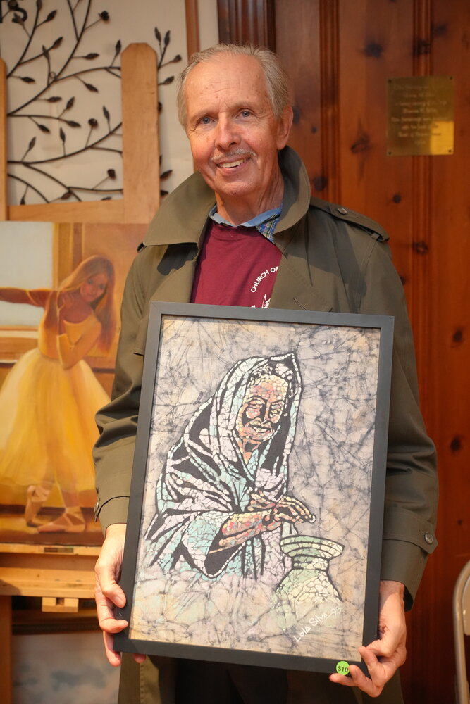 Nate Green purchases a piece of artwork at the Church of the Ascension Friendship Fair.