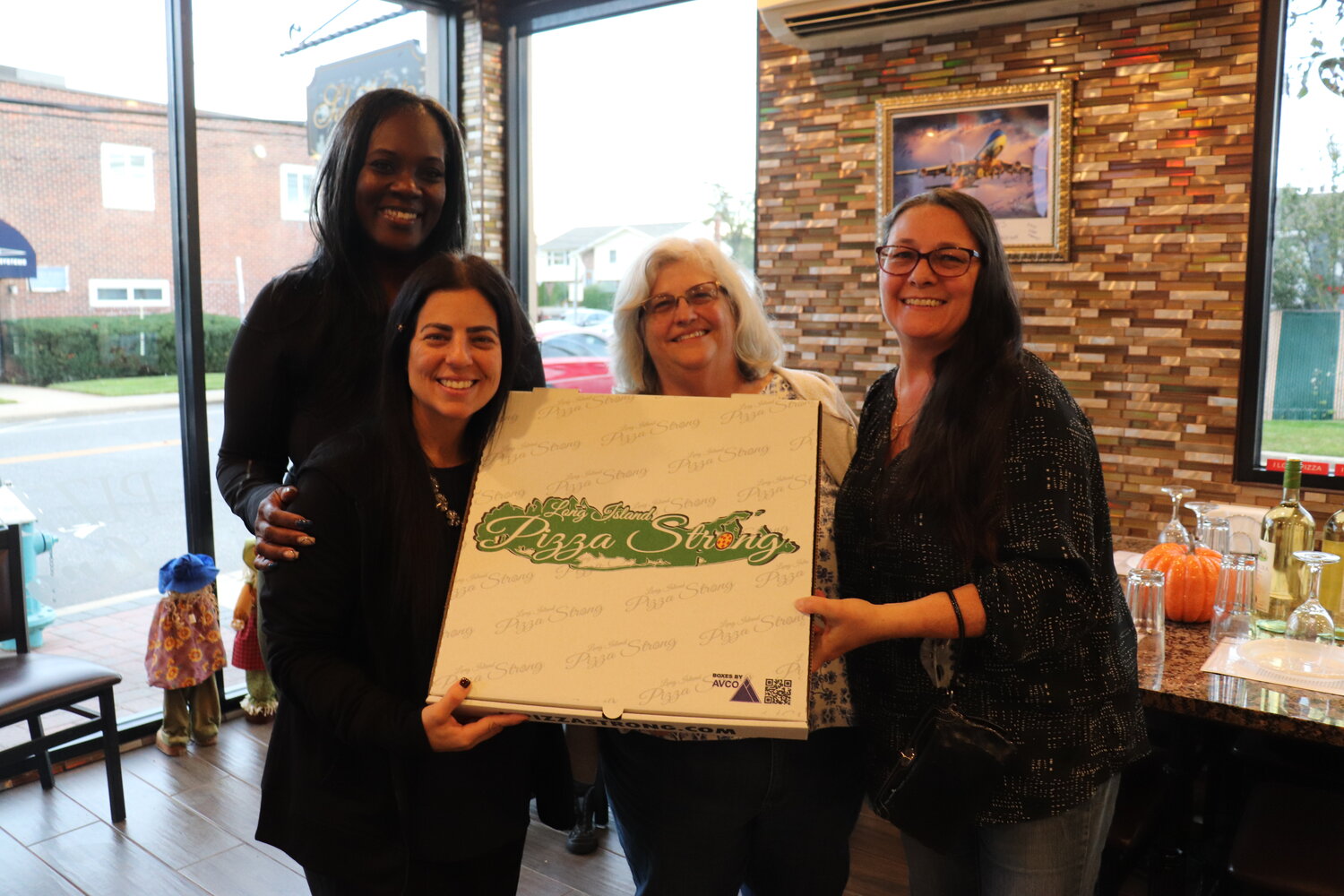 Maggie Samlal of Elmont, Anna Cortesiano, owner of Salvatore’s of Elmont, Lori Walz of Garden City South, and Kathy Elfassy of Elmont helped raise money for families affected by the Sept. 21 Farmingdale bus tragedy.