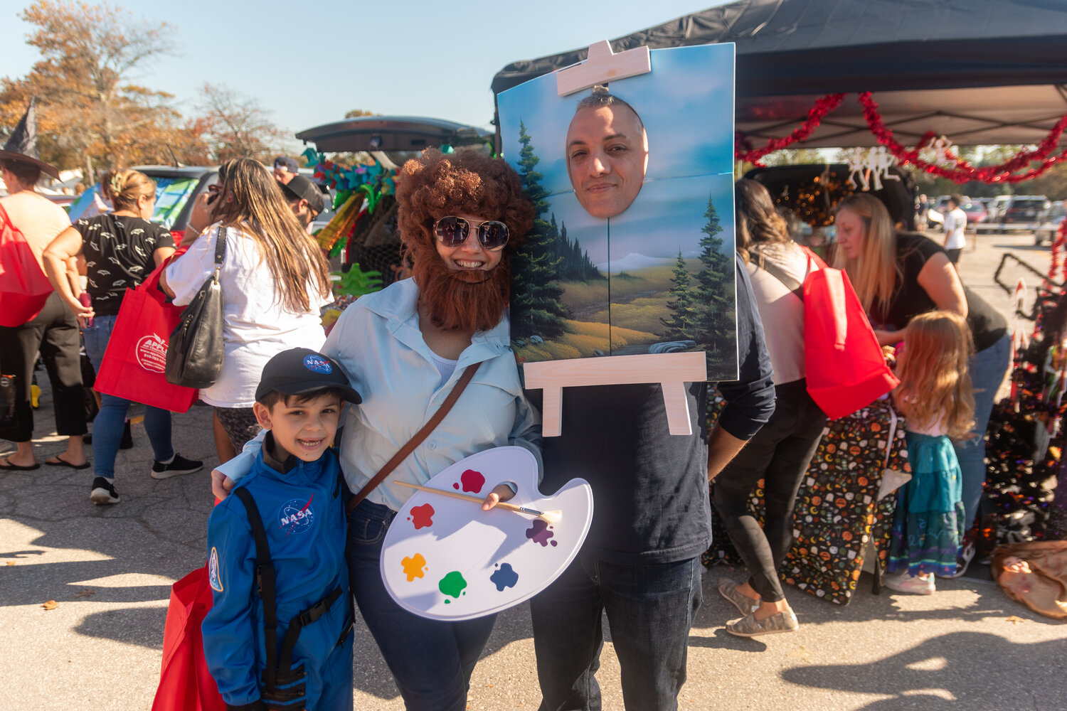 Parents David and Christina Kinares in a Bob Ross costume while their son, Dario, 7, dressed as an astronaut.