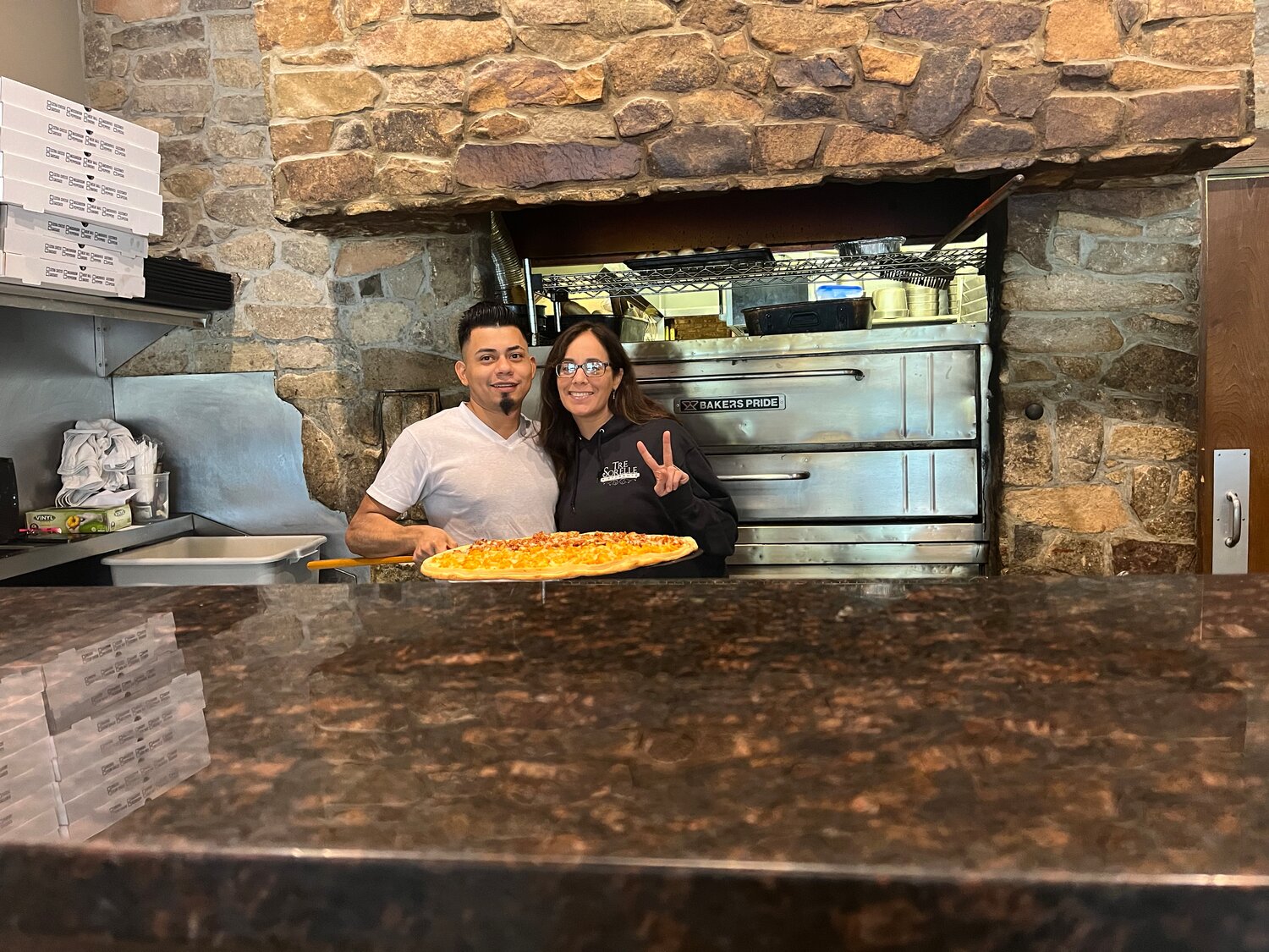 Summer Butindari, right, co-owner of Tre Sorelle, helped raise money for the fundraiser by selling pizzas with the help of her "main pie man" Alvaro Panameno.