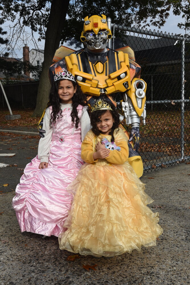 Gregg Cajuste, lieutenant governor of the Franklin Square Kiwanis Club, dressed as Transformers favorite Bumblebee with Isabella Villa, 7, and Gabriella Villa, 4.