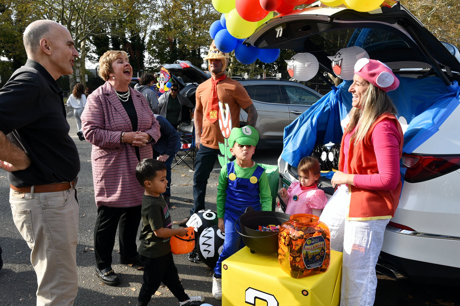John Giuffré, county legislator, Kate Murray, town clerk, and Thomas Muscarella, town councilman, chatted with the Giammarco family at the Nov. 5 trunk-or-treat in Franklin Square.