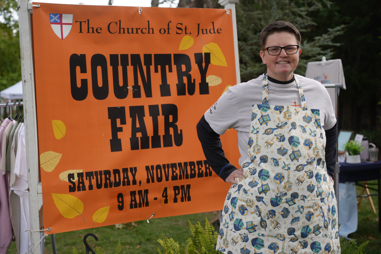 Rev. Jimmie Sue Deppe standing in front of the sign for the Country Fair. The event saw raffle baskets, handcrafted items for sale, and entertainment for children.