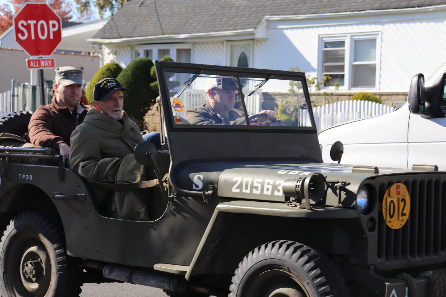 Matthew Berrell, an air force veteran who served in the Iraq War, rode with grandfather Ed Berrell, who served as a merchant marine in World War II and in the army during the Korean War, as father Matthew Berrell Sr. drove the car during the Veterans Day parade in Elmont on Nov. 11.