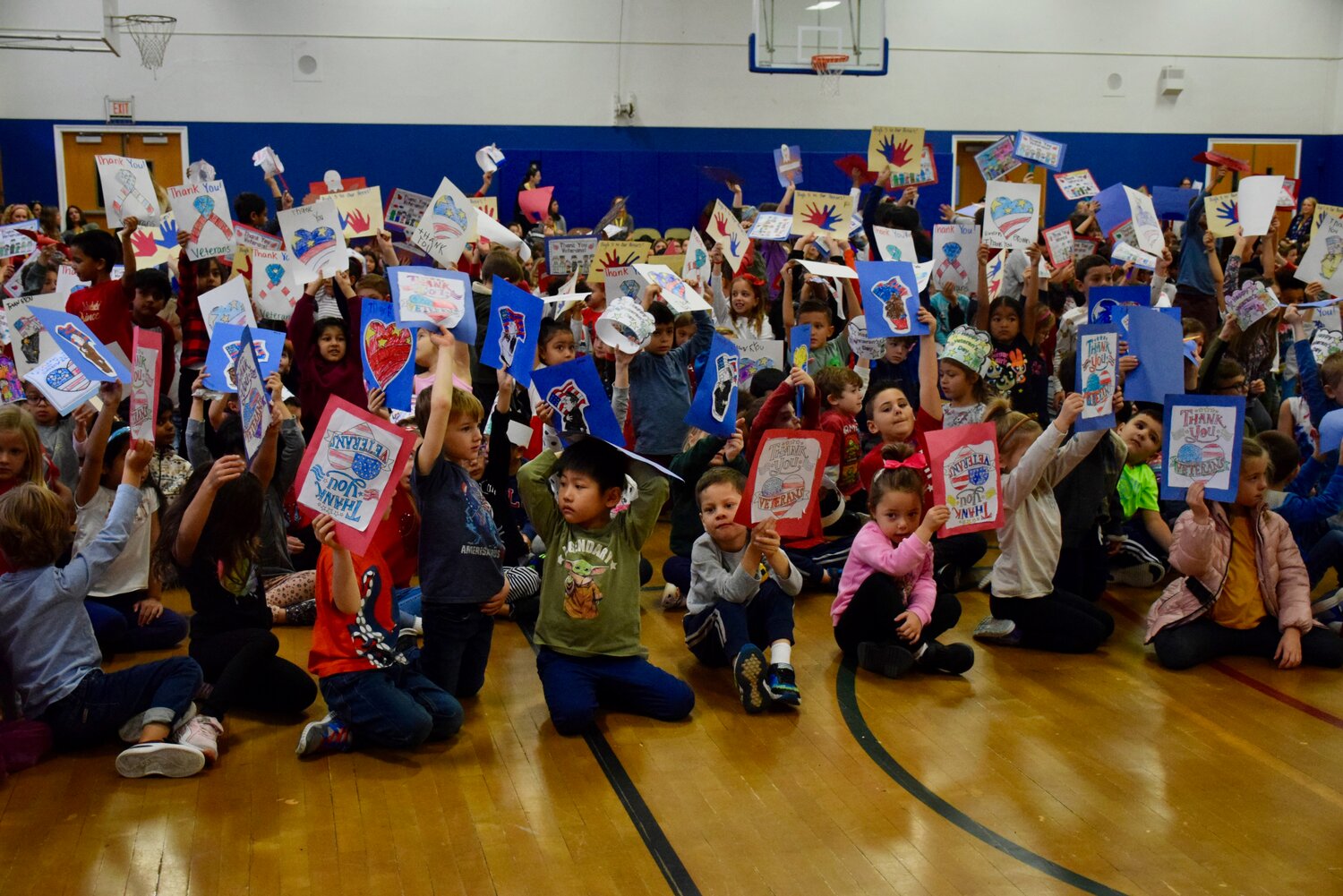 Students held up their artwork at the assembly held at Washington Street School last week as the school community celebrated and honored veterans.