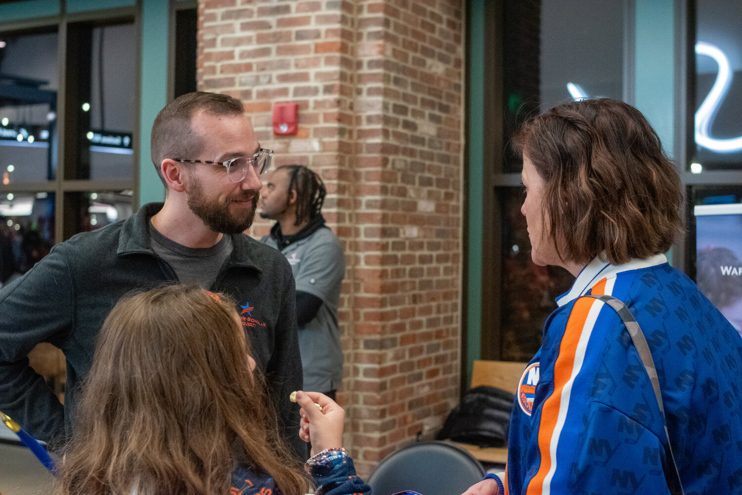 Ryan Pavel, chief executive of Warrior-Scholar Project, spoke with Gretchen Tine, 9, and Donna Tine about the opportunities the organization provides veterans during the New York Islanders military appreciation night on Nov. 11.