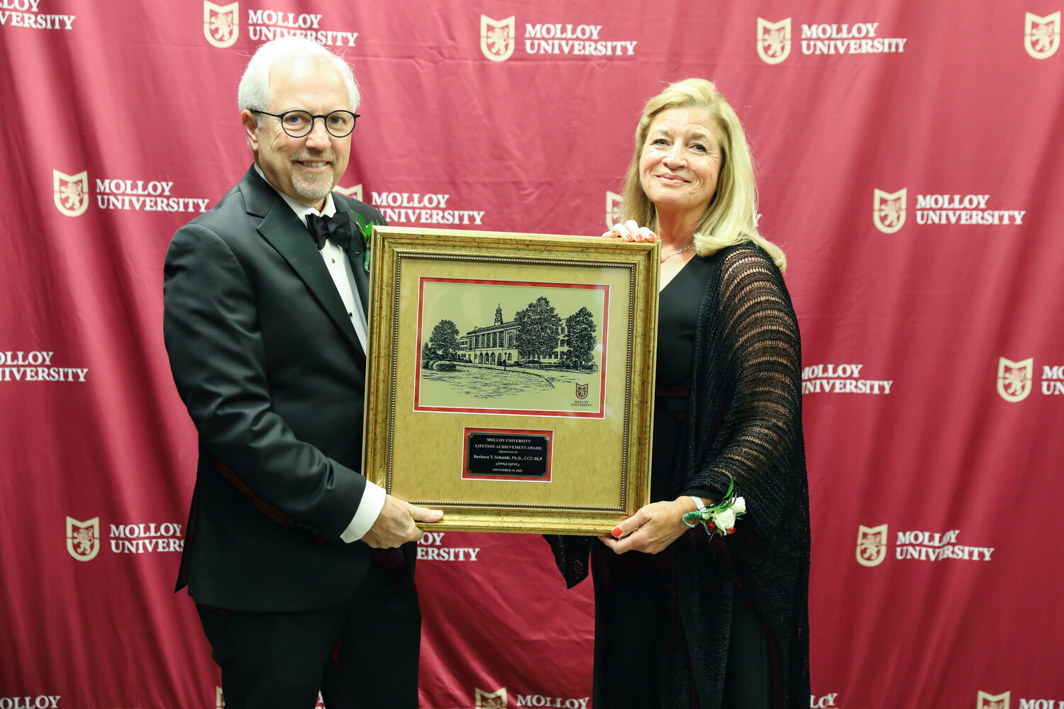 Molloy University President James Lentini, left, presents Gala Honoree Barbara Schmidt of Rockville Centre with the coveted Lifetime Achievement Award for her achievements, leadership and service within the community.