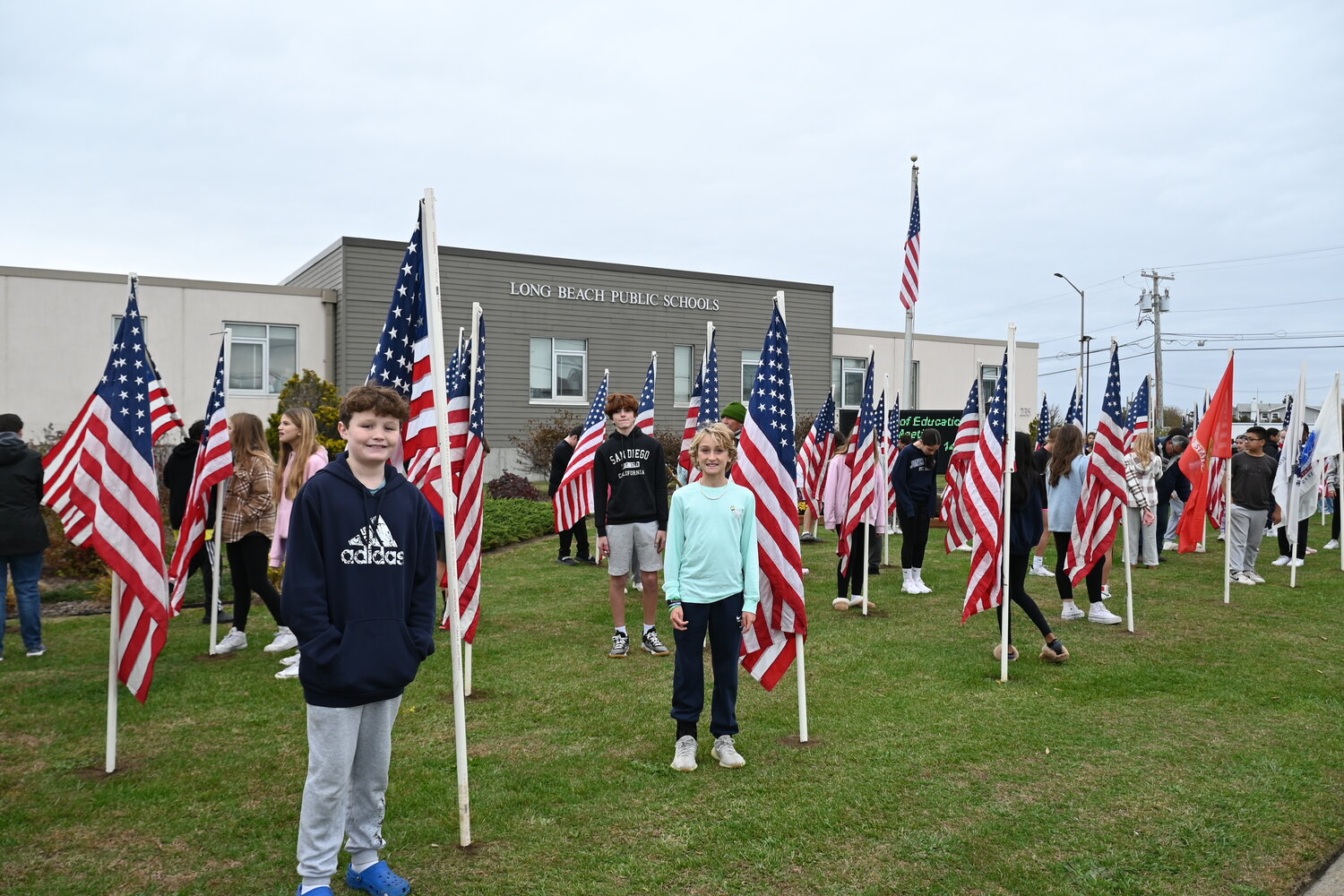 Students stood with the flags they placed along Lido Boulevard in honor of those who have served.