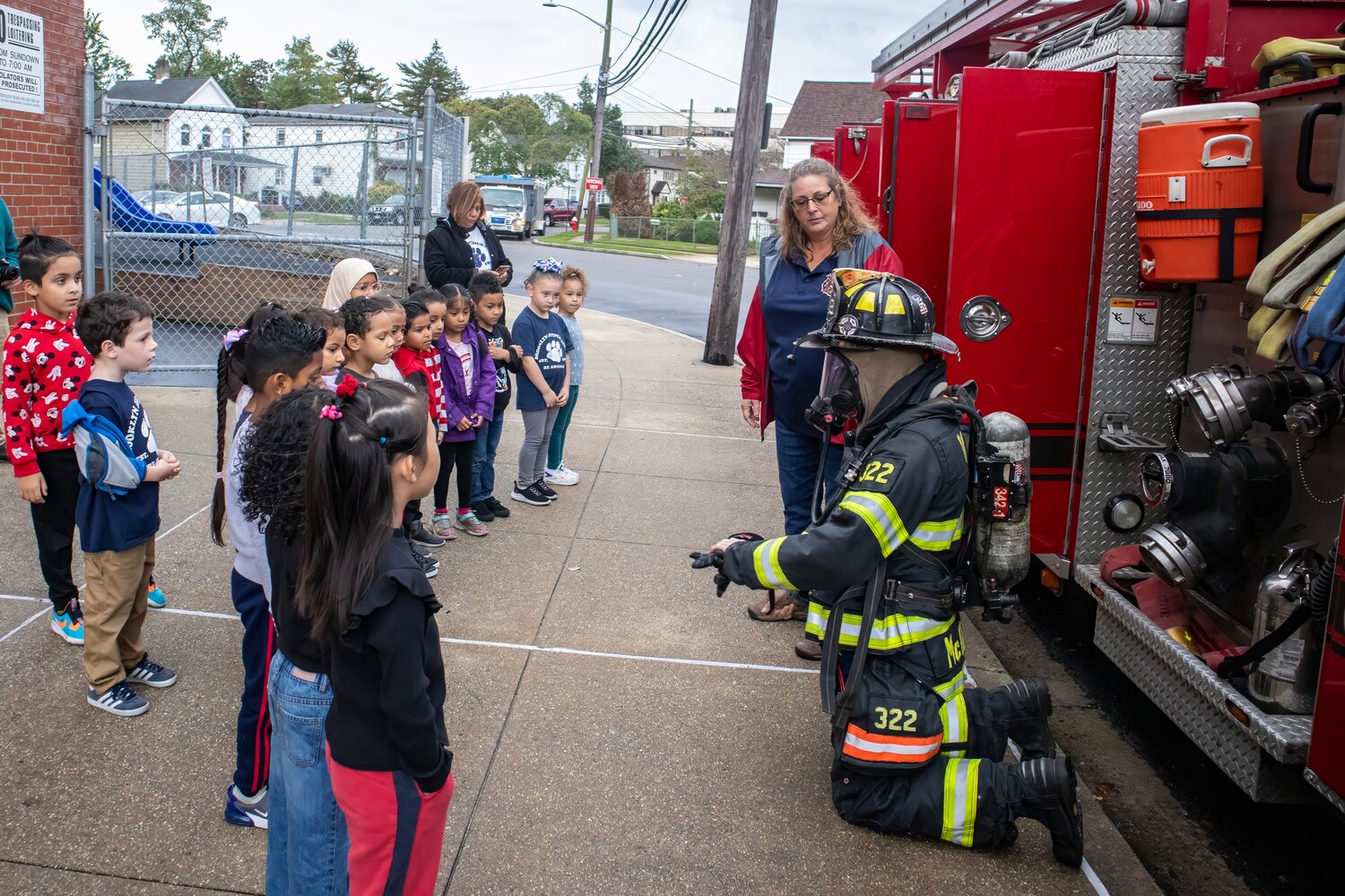 Brooklyn Avenue School students were treated to a visit by the Valley Stream Fire Department Fire Safety and Education Committee, alongside Ladder Company 2. Above, a uniformed firefighter explains the purpose of his equipment.