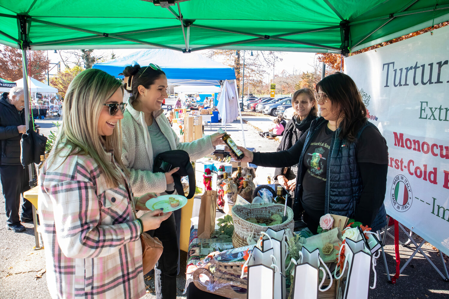 Colleen Dowling, left, and Lauren Hoskin checking out the olive oil from Mary Maragna and Antonella Turturici of Turturici & Sons, Inc.