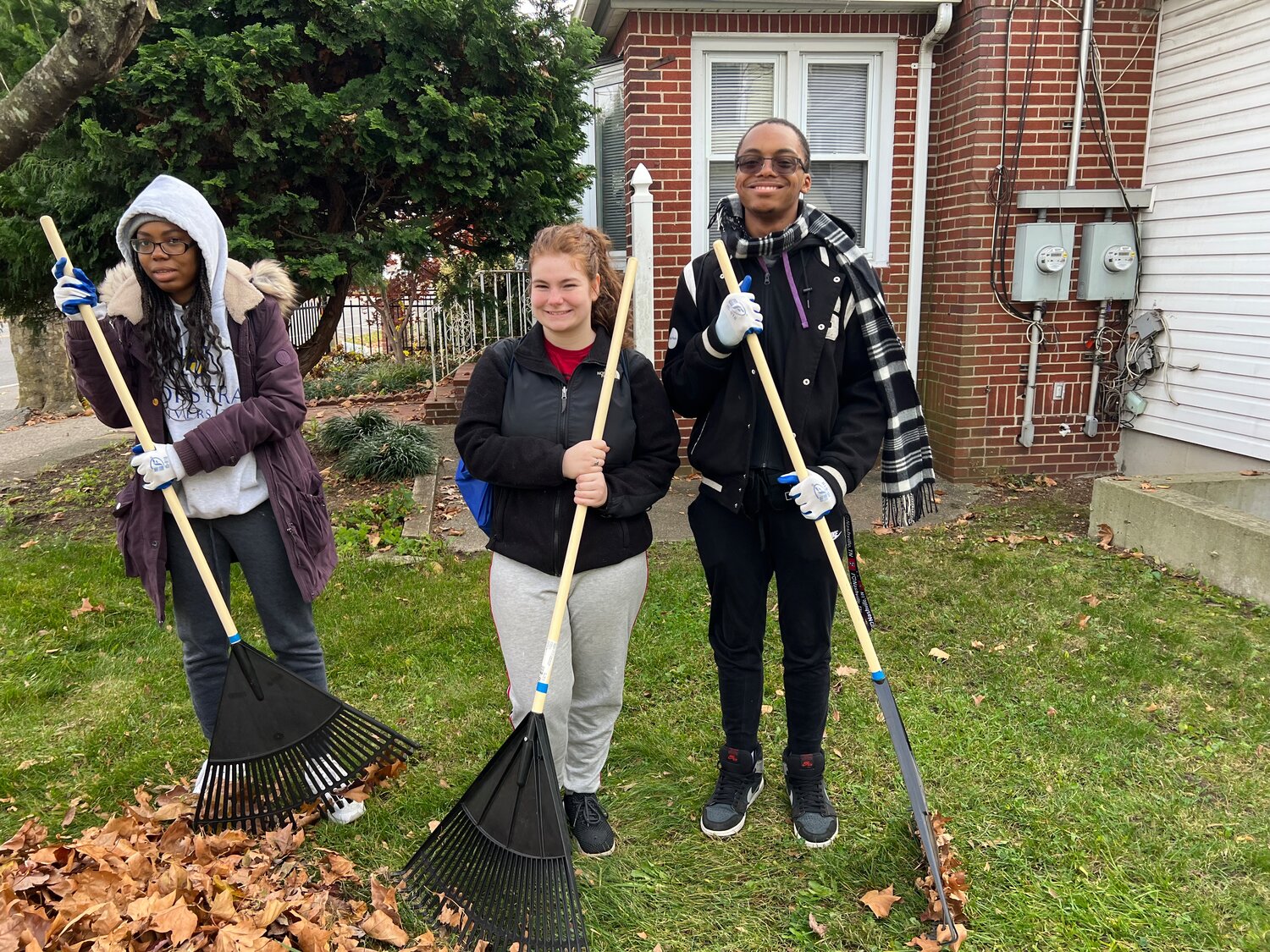 Three Hofstra students with three different majors all joined Shake-A-Rake to “give back to the community.” From left, criminology major Noemie Desruisseaux, 19, graduate family and consumer science major Caitlin Brophy, 22, and philosophy, rhetoric, and public advocacy major Maximillien A. Raymond, 20, pitched in with about 20 other students at the John J. Byrne Community Center.