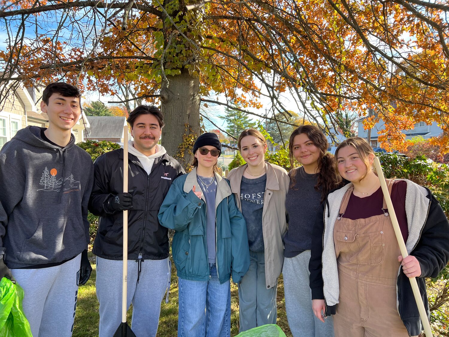 Six Hofstra 19-year-olds transformed the Rhodes lawn on Southern Parkway from a morass of leaves to a carpet of green. Music major Devan Saez, left, marketing major Ralph Barba, fine arts major Rosalie Mafoglio, biology majors Emma Ferland and Mirsela Redzematovic, and labor studies major Rylie Olsen all responded to an e-mail inviting their participation in Saturday’s Shake-A-Rake event.
