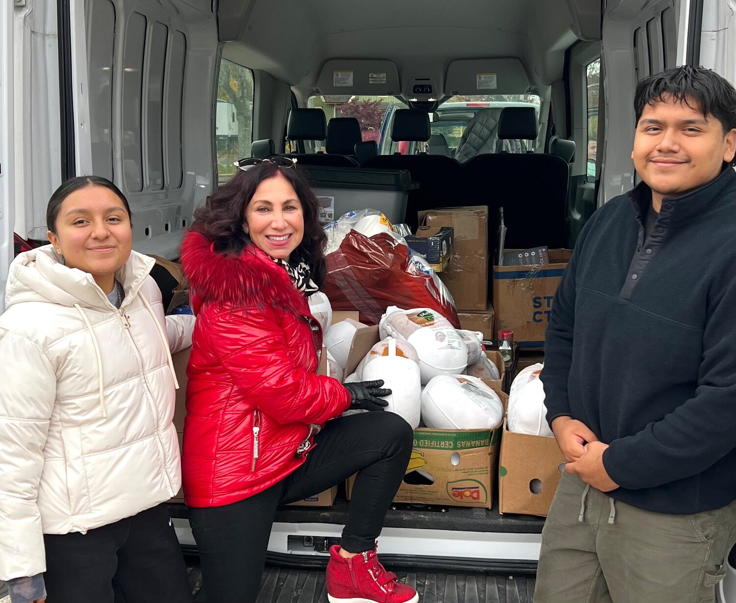 Silva, left, Kelly and Josh Cadmilema unloaded a van of turkeys from the North Shore Hispanic Chamber of Commerce.
