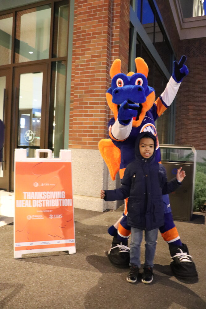 Carder Williams, 8, and his family from Queens grabbed a meal for the holiday from UBS Arena and the Islanders Children’s Foundation on Nov. 20. He posed with Sparky as the family waited to grab their Thanksgiving dinner.