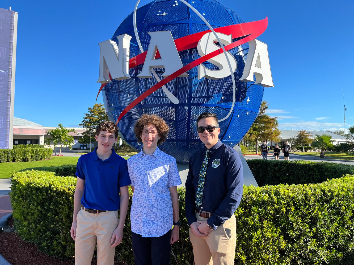 Aiden Michaels, left, and Jack Murray, center, are the first students from Lynbrook to send a science experiment to outer space. They, along with their teacher and collaborator, Stoycho Velkovsky, right, were invited to the Kennedy Space Station in Florida, where they presented their experiment to a panel of NASA experts.