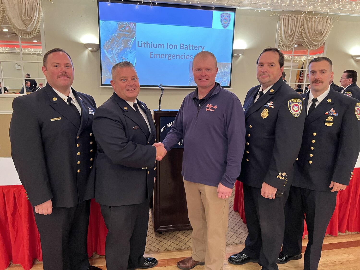 Chief Danny Ambrosio, shaking hands with FDNY Chief Edward Ryan, a former member of the Lynbrook Fire Department, after his presentation to the department membership on fighting battery fires and battery safety. First Assistant Chief Scott Bien, left, and Second Assistant Chief Clayton Murphy, and Third Assistant Chief James DiGiambattista, join in.