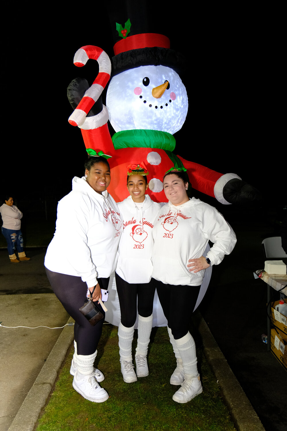Sarah Jean-Francois, 17, Ariana Polizzo, 17, and Jolie Rannarine , 17 of Tip Tap Toe Dance Studio are all smiles with a snowman at the tree lighting ceremony hosted in Garden City South Park last weekend.