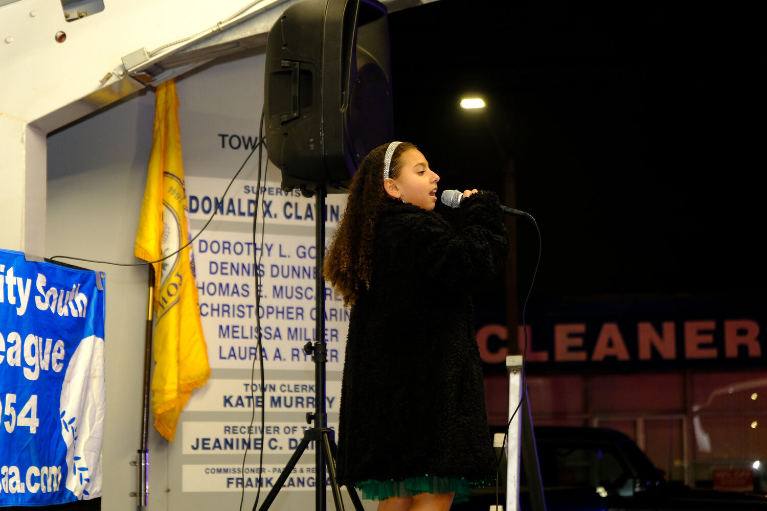 Sogna Bella, 8, sings for the crowd as she takes the stage during holiday festivities at Garden City South Park on Dec. 2.