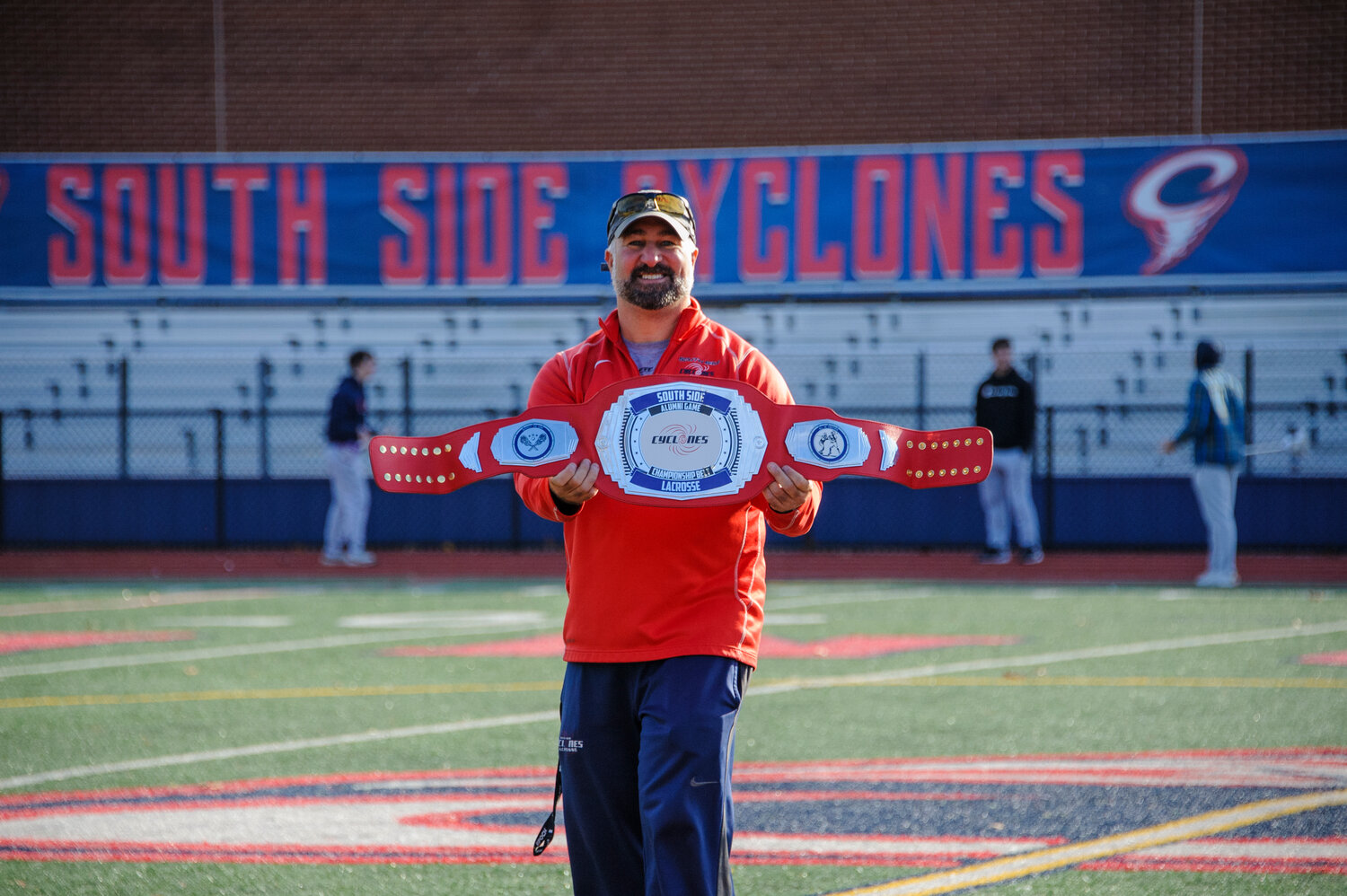South Side Lacrosse Coach Steve DiPietro holds up the championship at the 5th annual alumni lacrosse game.