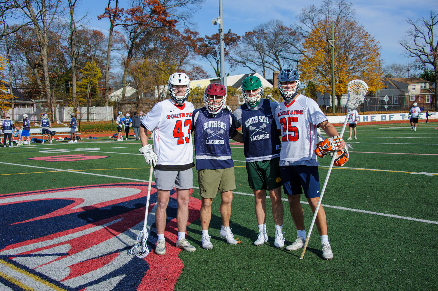 Liam Kassl, No. 43, Aidan Kelly, No. 22, Bobby Meindel, No. 44, and Joe LiCalzi, No. 25, catch up during the South Side alumni lacrosse game on Nov. 24.