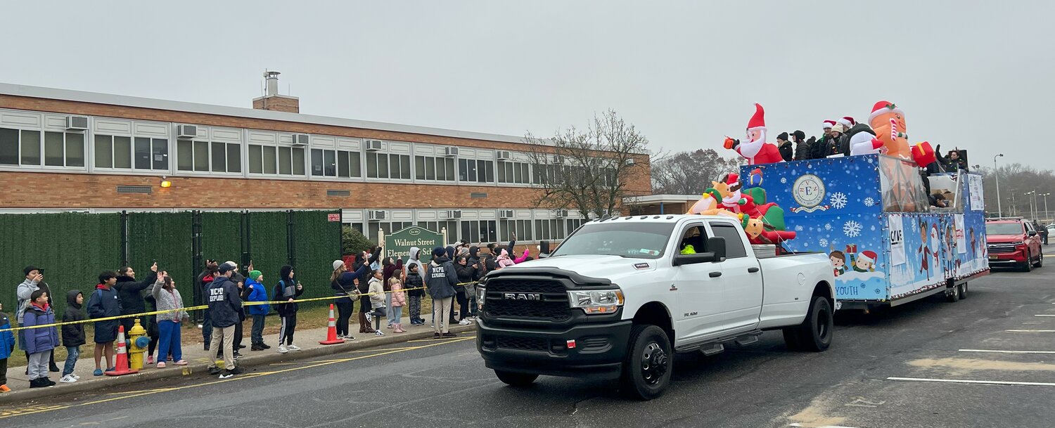 Hundreds of parents and children from the Uniondale school district gathered at Walnut Street Elementary School last weekend for a toy giveaway sponsored by the Nassau County Police Department Foundation. Following the truck in the parade of vehicles is the red car carrying Uniondale fire chief Jessica Ellerbe.