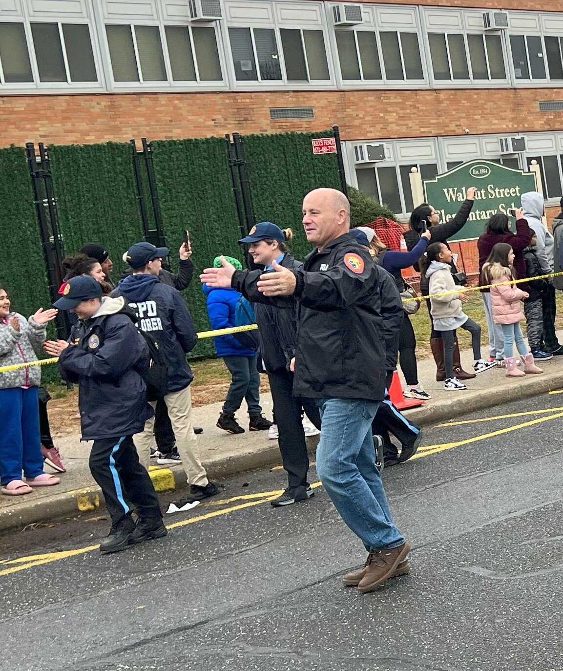 As the truck full of free toys approached the Walnut Street Elementary School entrance, Nassau County Police Department commissioner Patrick Ryder traversed the waiting line of family and children, energizing the crowd.
