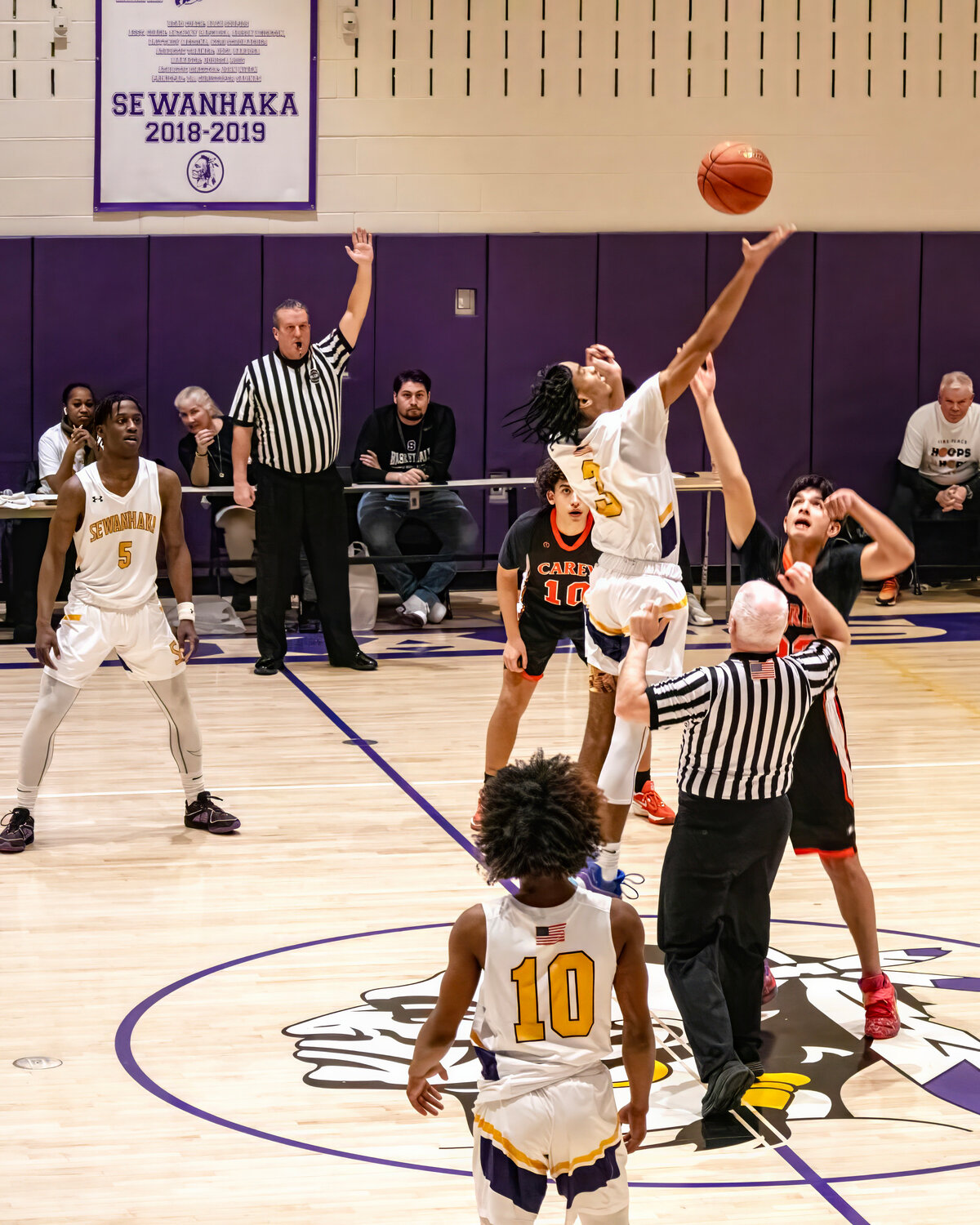 Sewanhaka’s Dylan McLennon gets the tipoff from Carey’s David Yussof as Kevin Colvin, Jordon Tucker and Nasir McMillian look on during the Hoops for Hope charity basketball game at Sewanhaka High School last Friday.