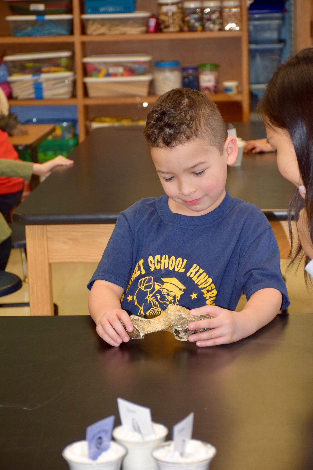 A Franklin Square student gets hands-on experience with a dinosaur fossil during math and science experience week at Franklin Square’s John Street School.