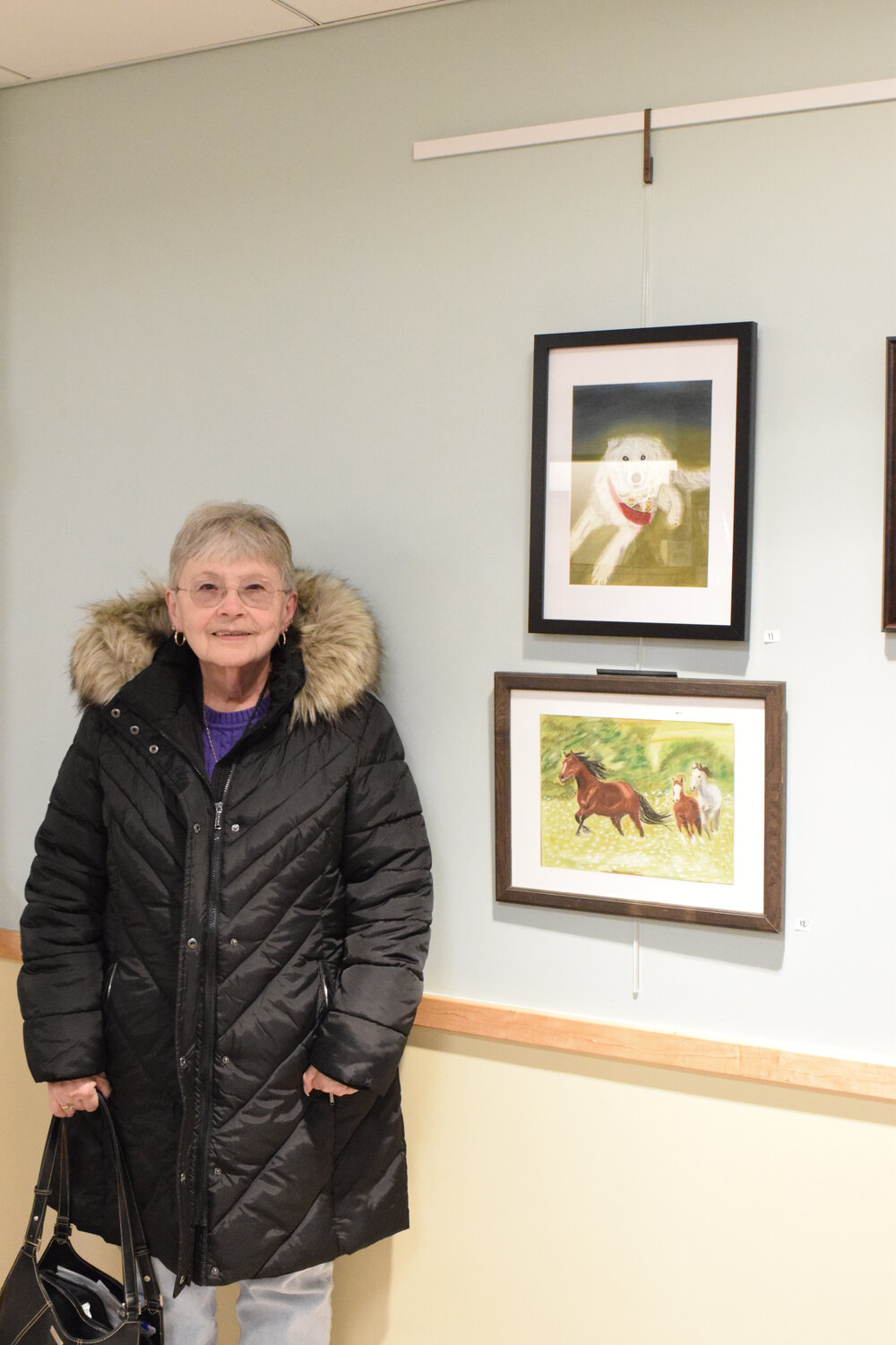 Judy Aubin of Bethpage with her work at the reception. Throughout the room filled with artwork by 10 artists, certain pieces are for sale.