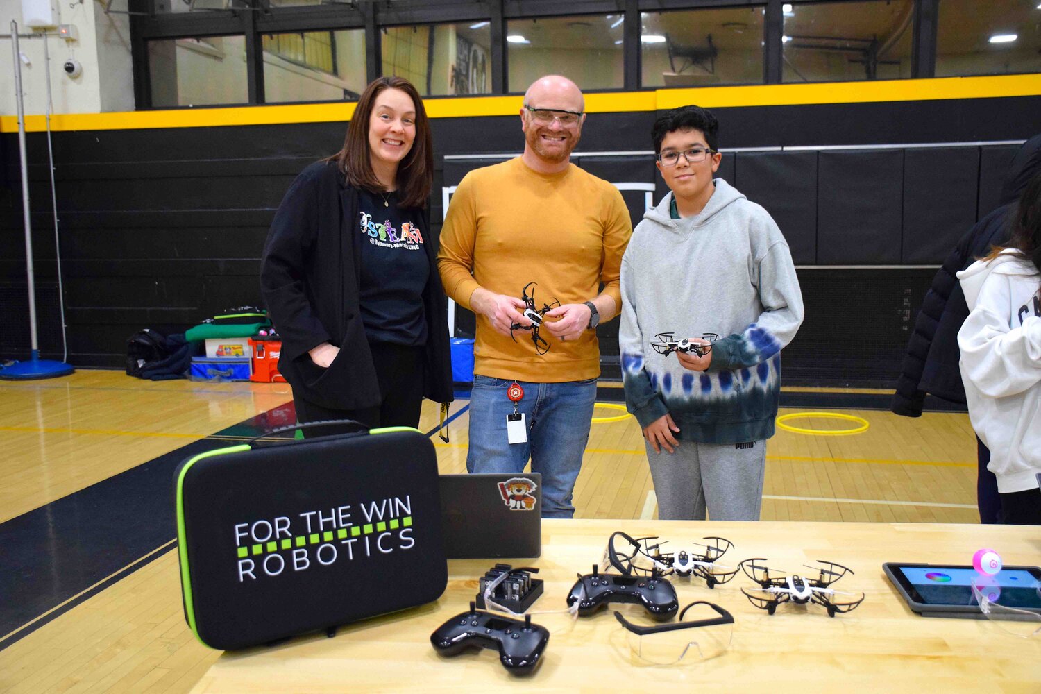 Merrick Avenue Principal Katelyn Dunn, technology teacher Dan Stiglitz and eighth grader Sebastian Obregon at the drone station.
