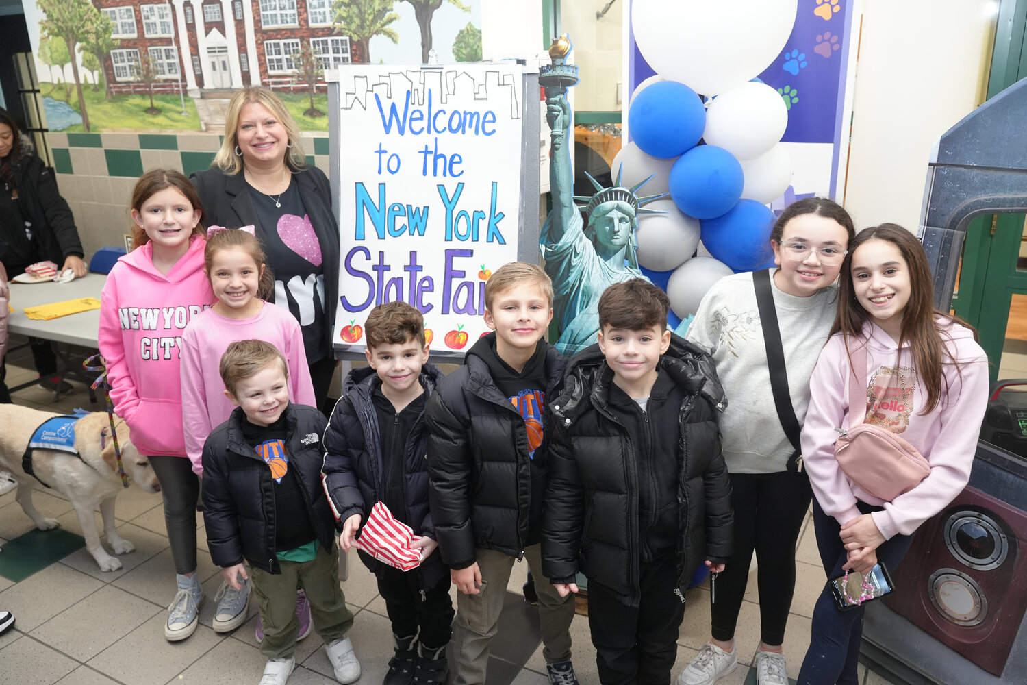 Hewlett Elementary School Principal Heather Sosnovsky and students welcome everyone to their Jan. 30 ‘state fair’ using New York City landmarks.
