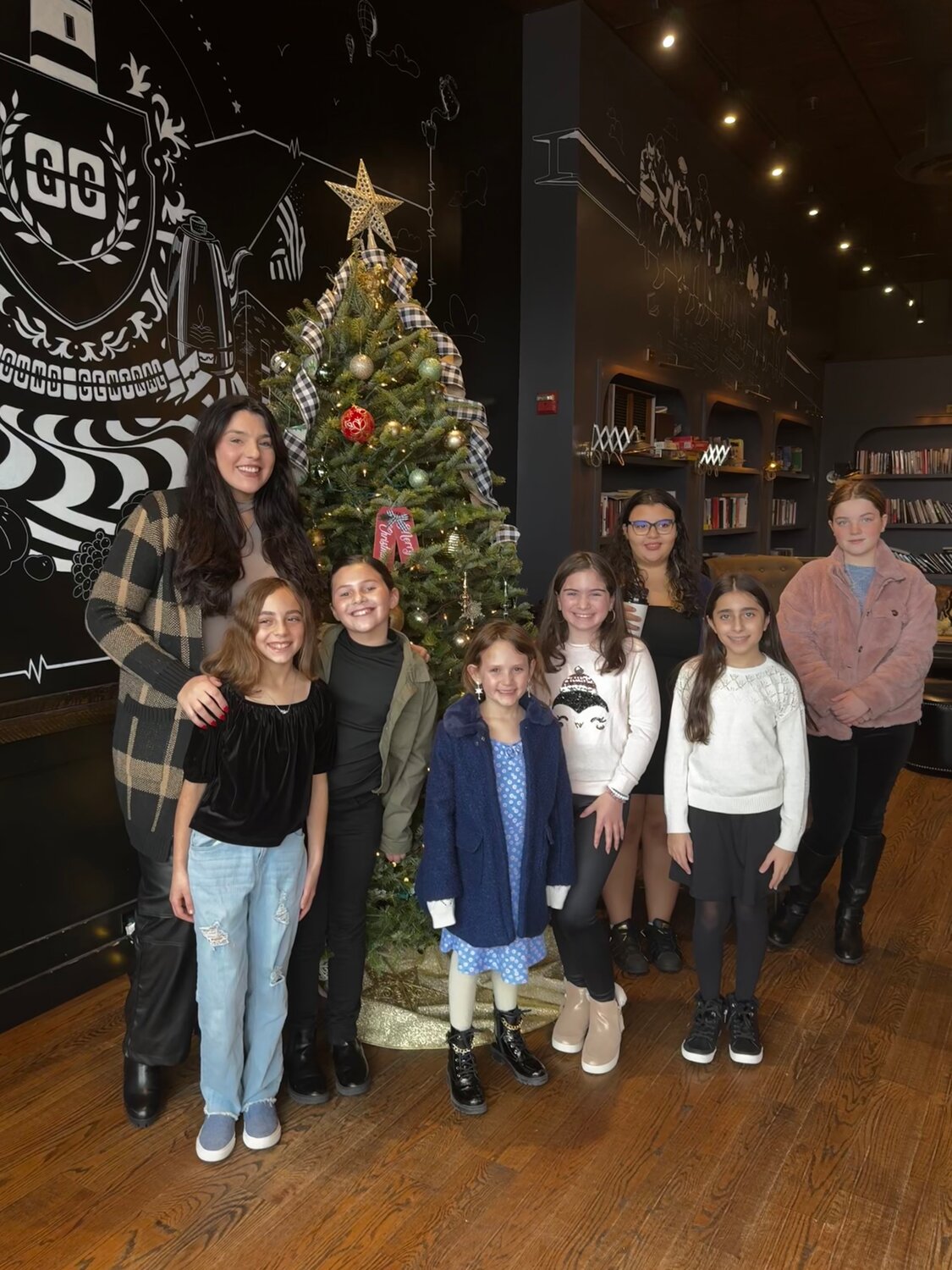Butler with a group of kids who take private voice lessons with her. They performed at Lynbrook Ground Central Coffee in October.