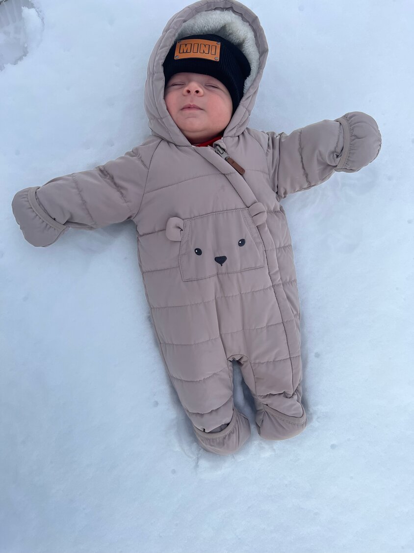 Baby Santiago is cozy as a bear, bundled up in the snow outside his Franklin Square home.