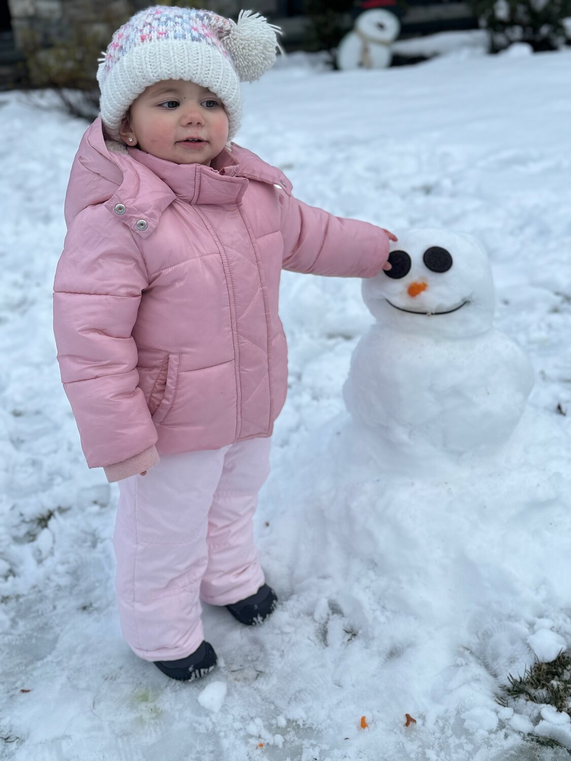 Emma of Oceanside posing with her first snowman!