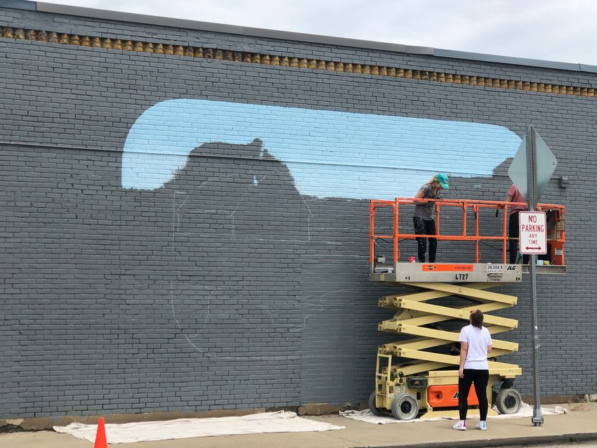 Samantha Cox pictured working on a &ldquo;surprise&rdquo; mural located at the four-way intersection of  E. Jackson St. and S. Crittenden.